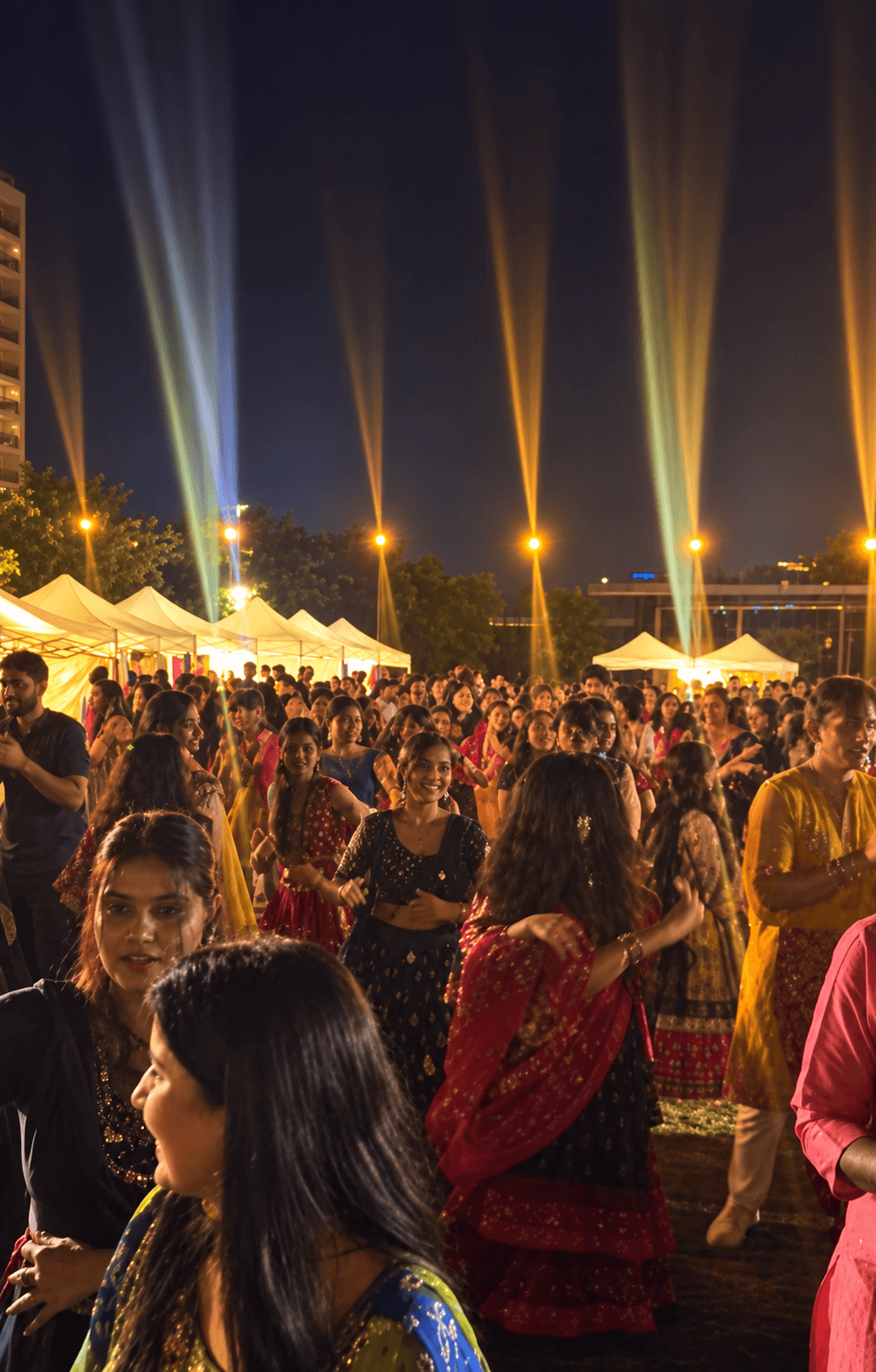 Large dancing crowd beneath the open-air event lights